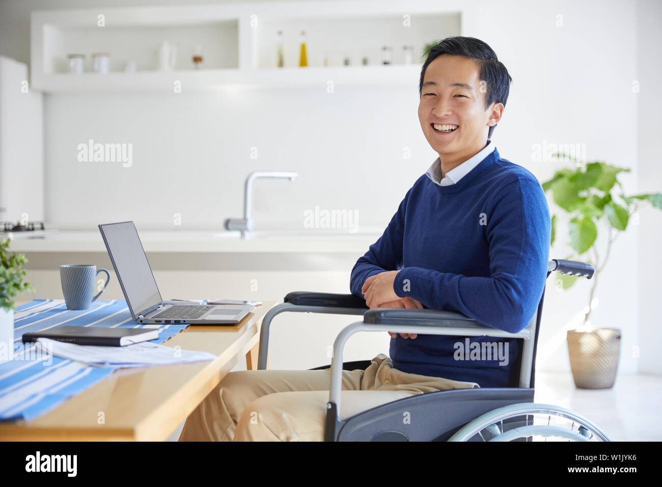 Japanese young man on wheelchair working from home Stock Photo Alamy