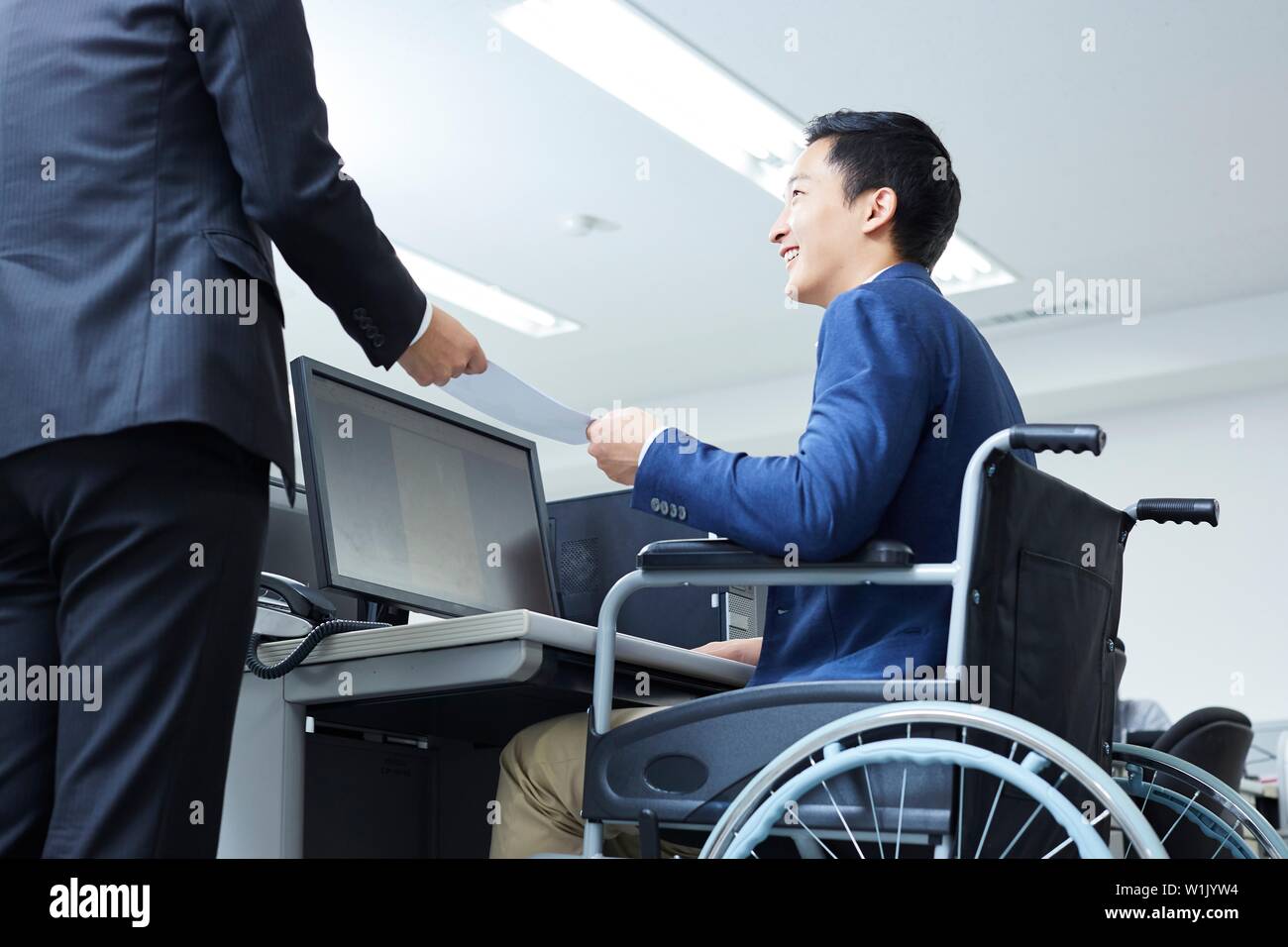 Japanese young man on wheelchair working Stock Photo - Alamy