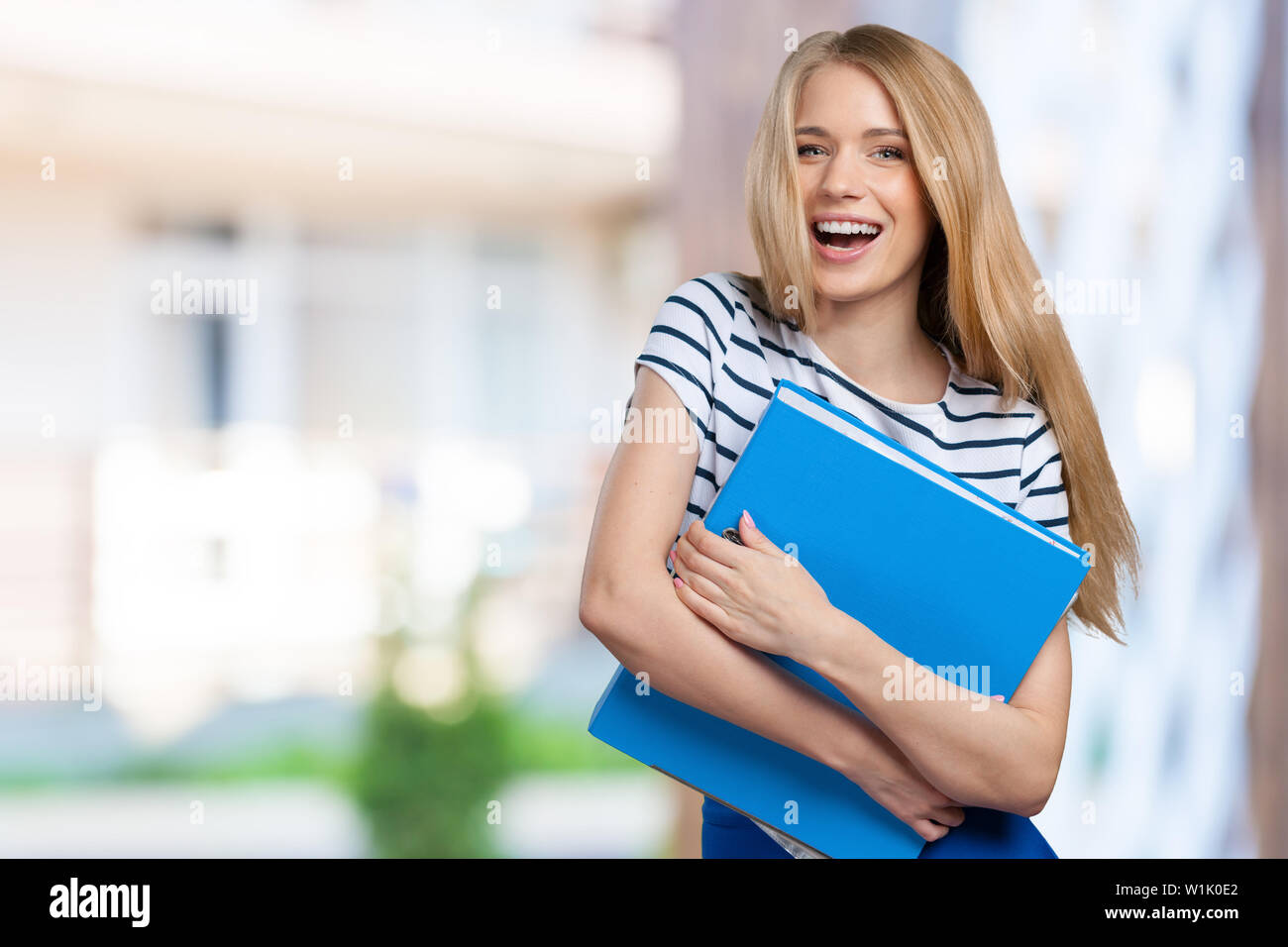 Portrait of smiling business woman with paper folder Stock Photo - Alamy