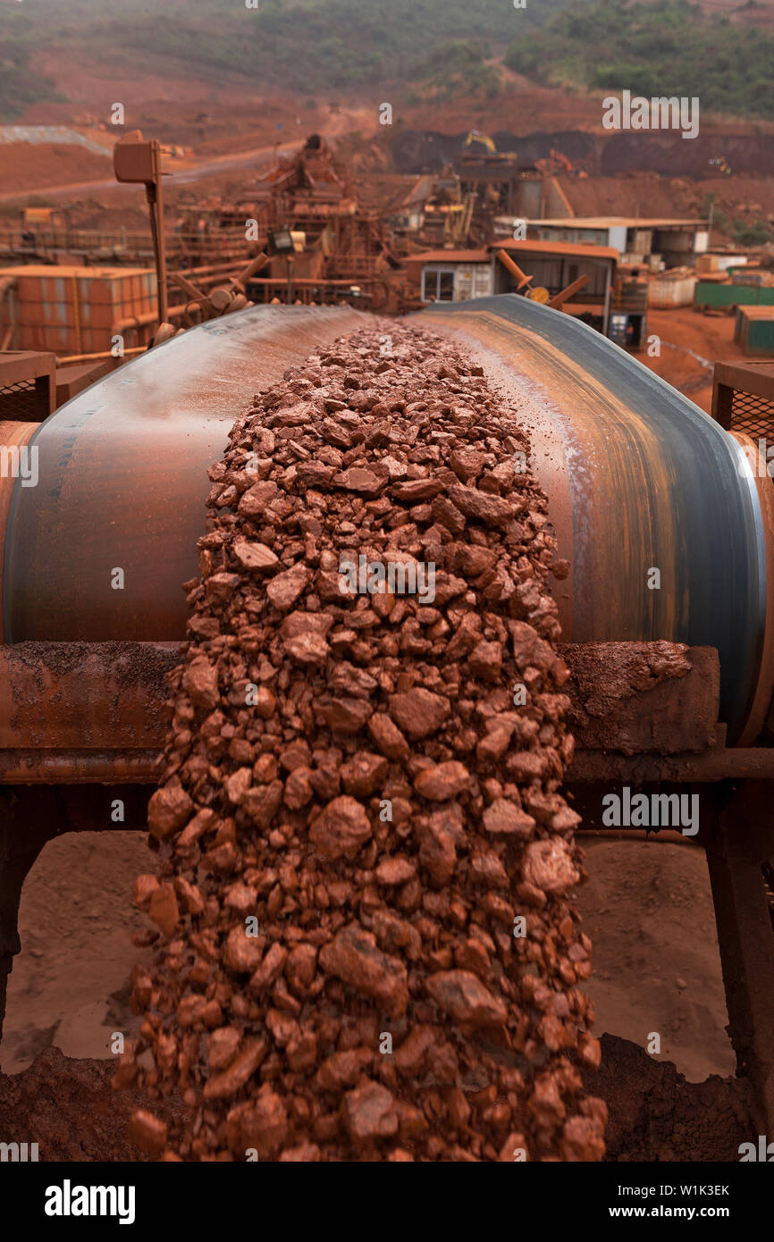 Mining operations for transporting a & managing iron ore. C/up lump ore product from crusher on conveyor at top of stacker, before transport by rail. Stock Photo