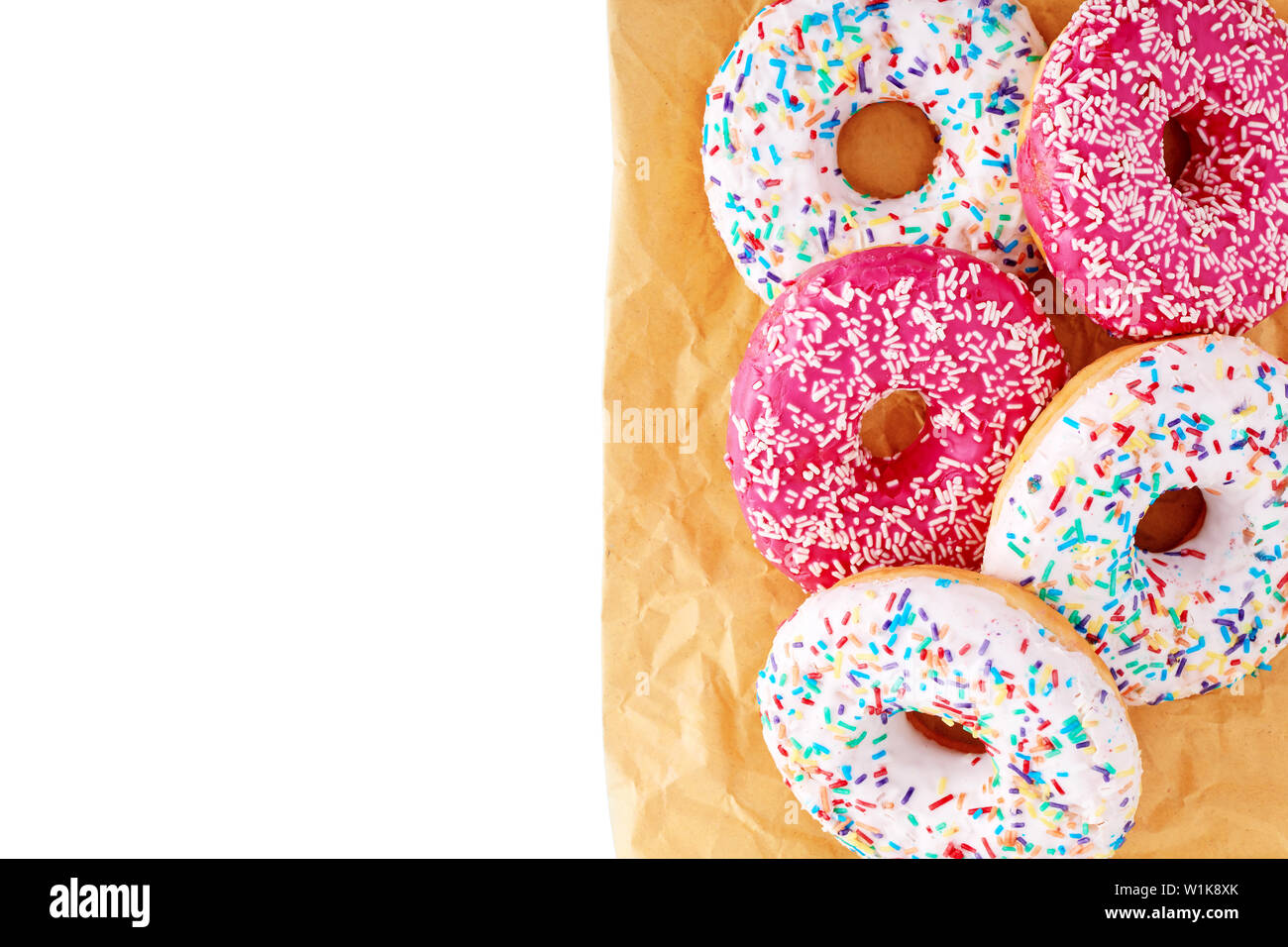 Colorful donuts on yellow paper bag on isolated white background. with copy space  Close up, top view. Stock Photo