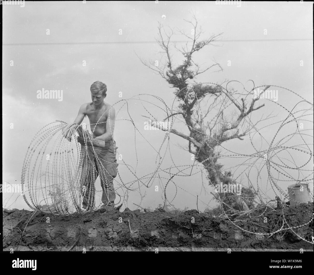 Vietnam....A member of the 1st Brigade, 5th Infantry Division (Mechanized), takes down barbed tape (a modified form of concertina wire) surrounding the command post of Operation Utah Mesa in the A Shau Valley. Stock Photo