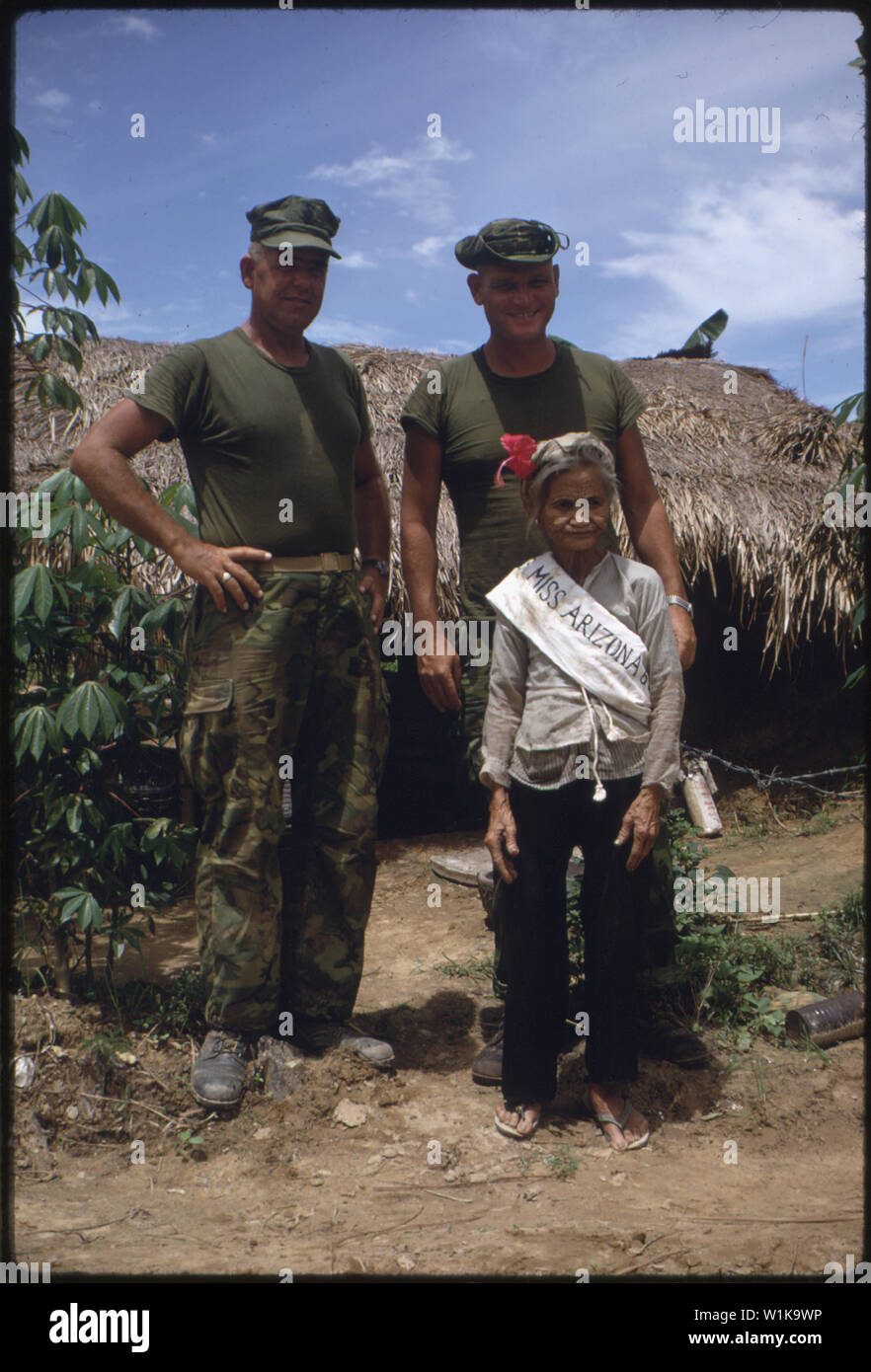 Vietnam....Sergeant Major Lewis E. Tuttle and Major O'Toole pose with an old woman in the Arizona Territory. The photo was originally shot as a joke, since the 1st Battalion, 5th Marine Regiment, was operating in the area known as the Arizona Territory at the same time the Miss Universe contest was being held in Tokyo. Stock Photo
