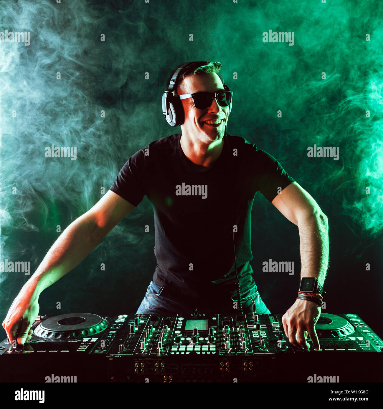 DJ mixing music on mixer on dark background Stock Photo - Alamy