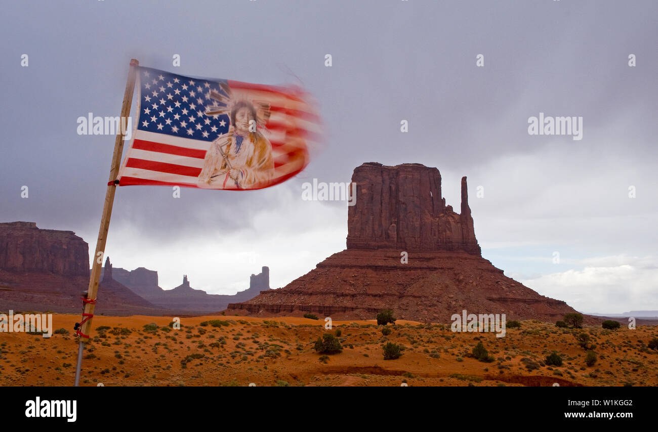 A tribal American flag blows in high winds as clouds envelope the rock formations in Monument Valley. (c) 2011 Tom Kelly Stock Photo