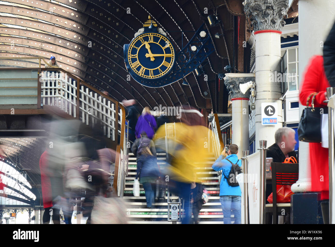 passengers passing station clock rushing to catch trains at york railway station united kingdom Stock Photo