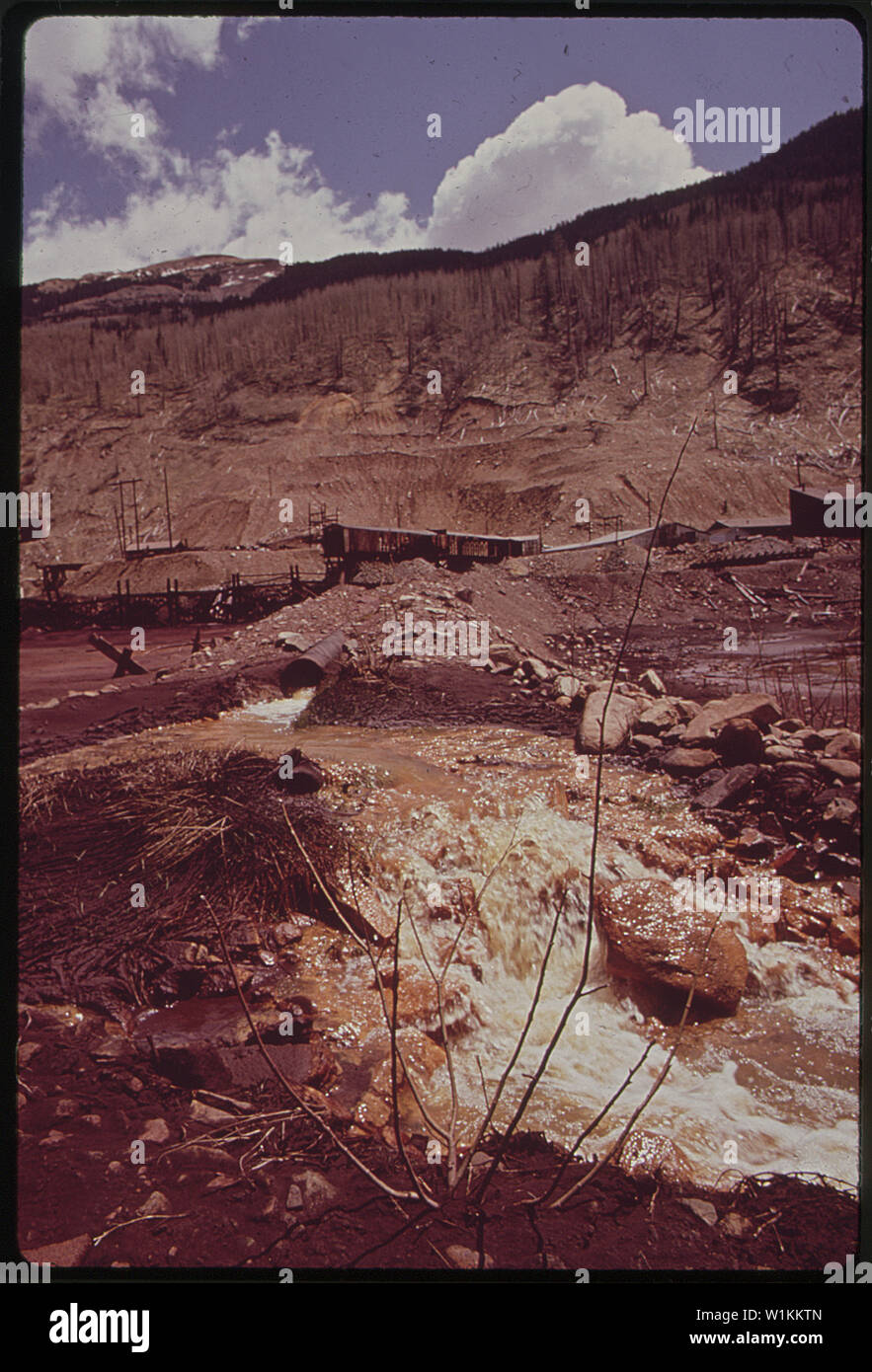 WATER SEEPING FROM CLOSED MINE CARRIES IRON OXIDE AND OTHER MINERALS INTO  NEARBY STREAMS. THE MINE BELONGS TO THE RICO-ARGENTINE MILL, WHICH PRODUCED SULPHURIC  ACID. THE PLANT WAS SHUT DOWN SIX YEARS