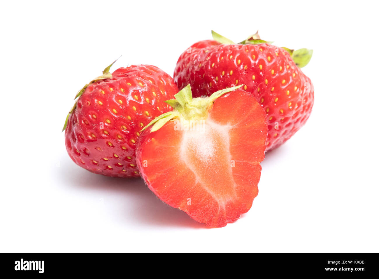 Description: Isolated strawberries. Two whole strawberry fruits and half isolated on white background, with clipping path Stock Photo