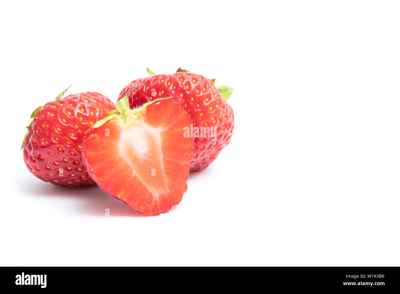 Description Isolated strawberries. Two whole strawberry fruits and half isolated on white