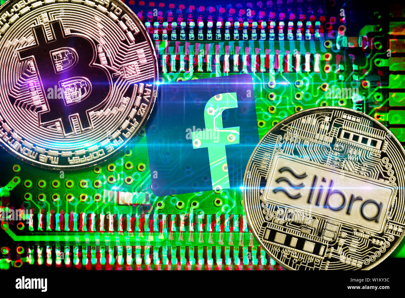 Facebook app logo and bitcoin and libra cryptocurrency coins on computer circuit board Stock Photo