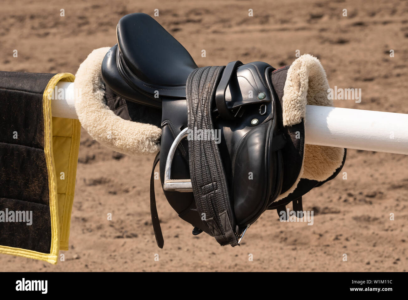 description: English saddle and bridle hanging on a wooden stable door Stock Photo