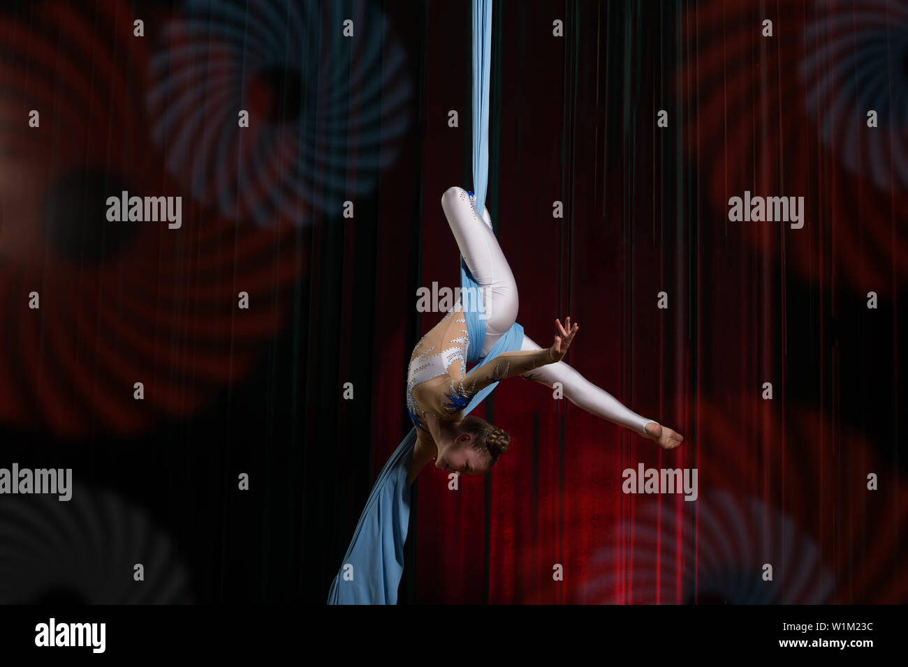 Circus artist acrobat performance on canvases. The girl perform acrobatic elements in the air. Stock Photo