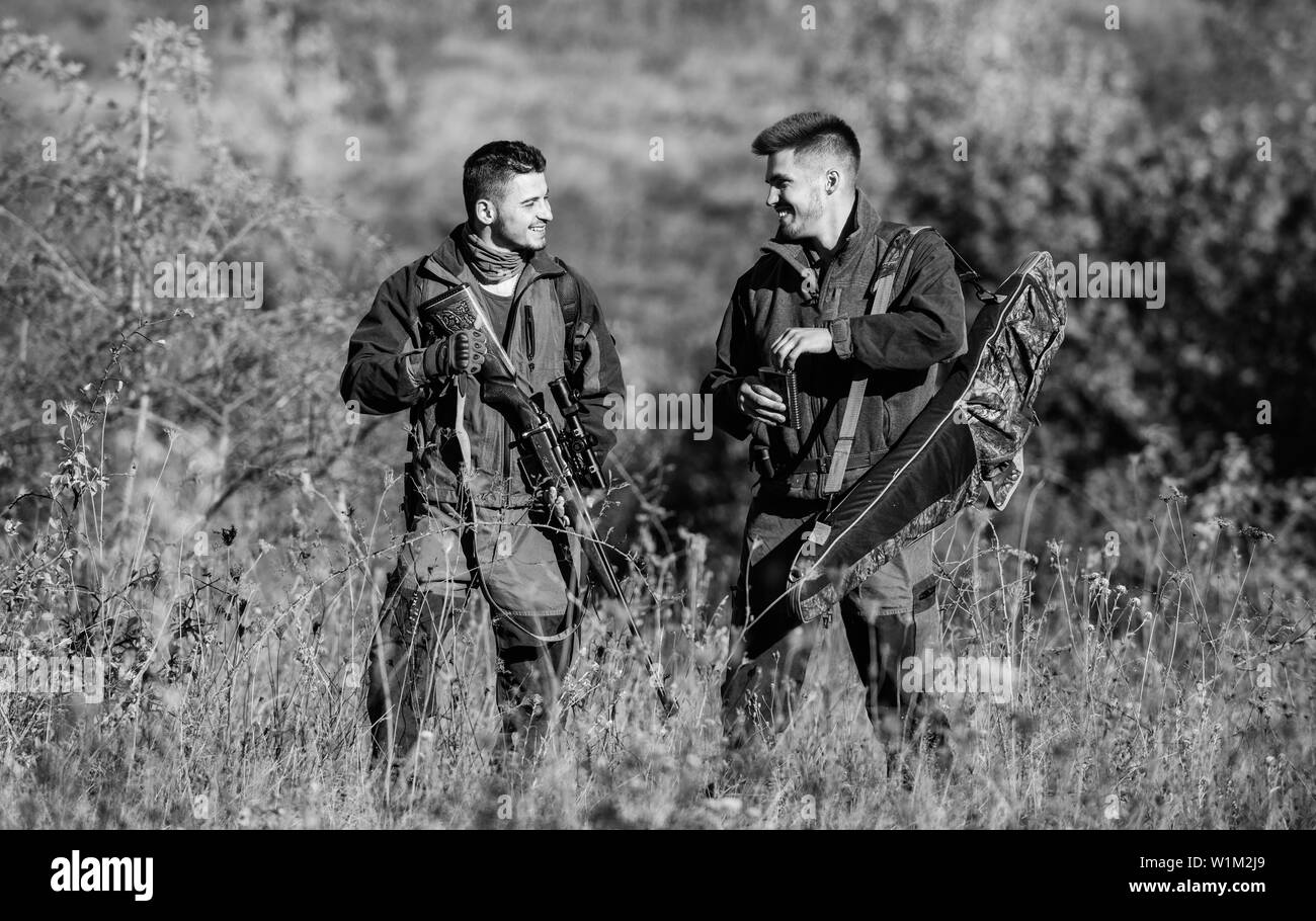 Army forces. Camouflage. Friendship of men hunters. Hunting skills and weapon equipment. How turn hunting into hobby. Military uniform fashion. Man hunters with rifle gun. Boot camp. friendly talk. Stock Photo
