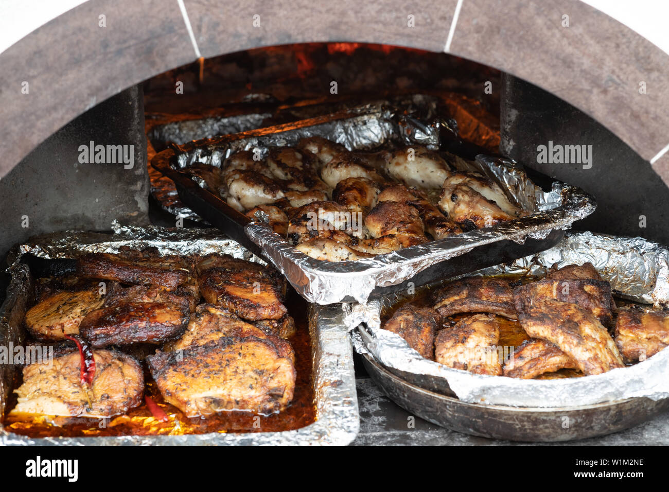 description: description: trays of cooked meat in the oven on the coals. Stock Photo