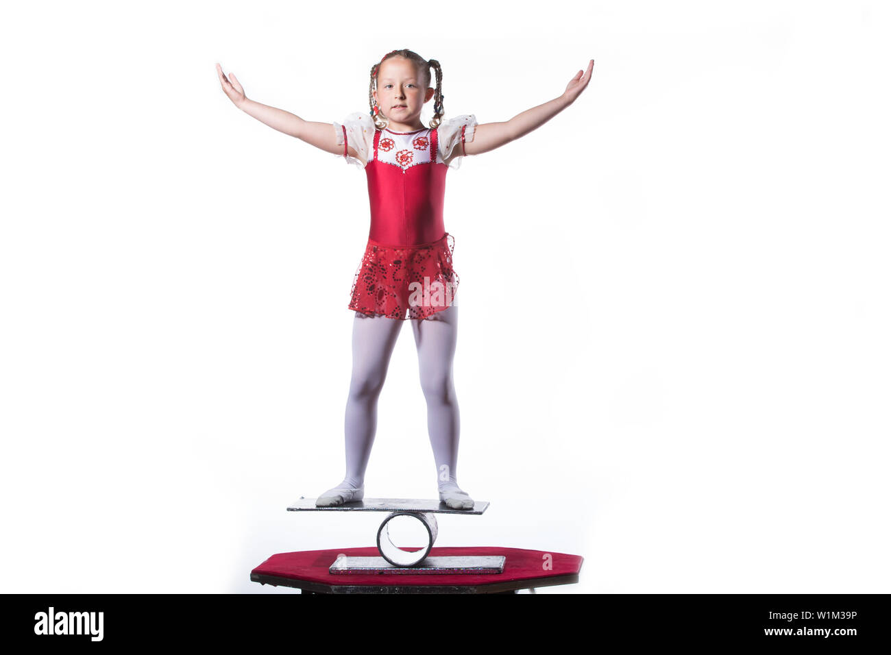 Little girl balancing act on white background.Young gymnast balancing actress Stock Photo