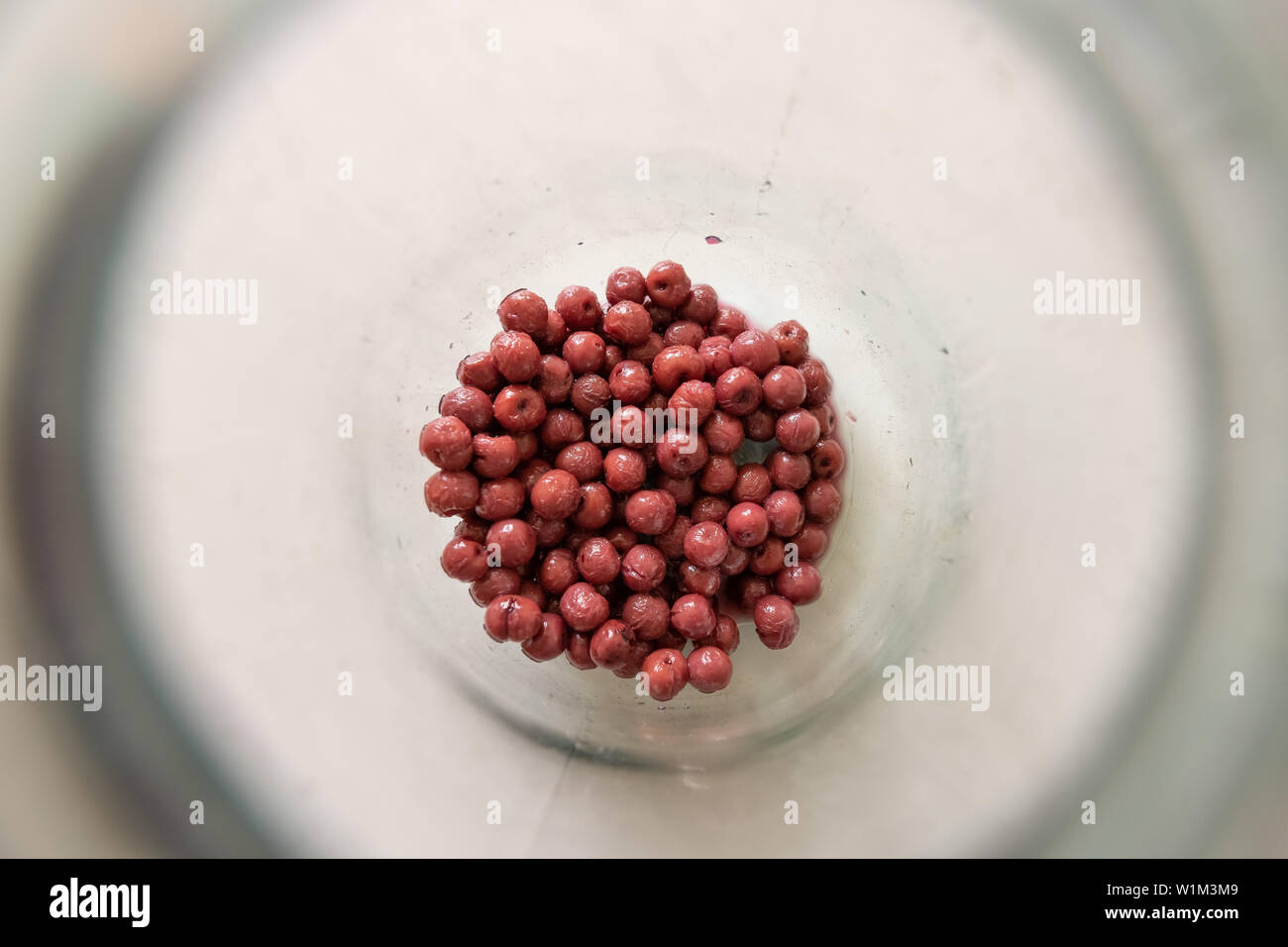 description: Berries in a glass jar of compote. Harvest. Blueberries, red currants and cherries. Stock Photo