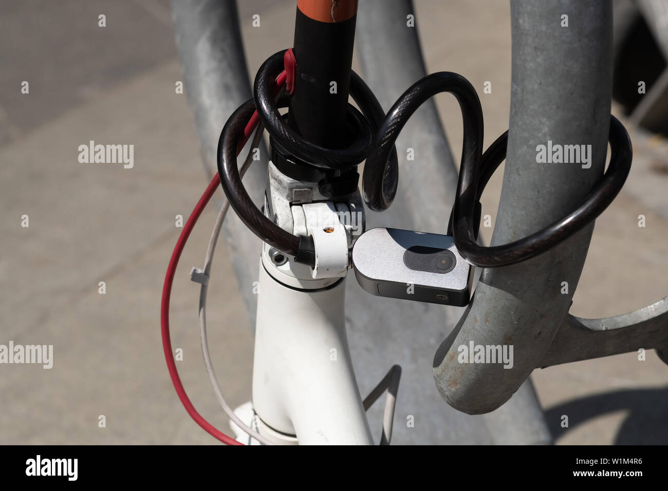 description: Combination security lock blocking the motor scooter wheel ...