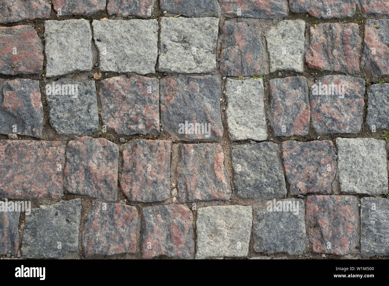 description: Stone pavement texture, granite cobblestoned pavement background, cobbled stone road regular shapes, abstract background of old cobblesto Stock Photo