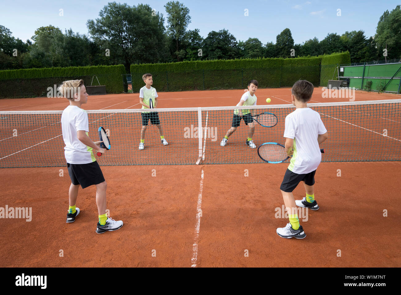 Young boys playing tennis, Bavaria, Germany Stock Photo