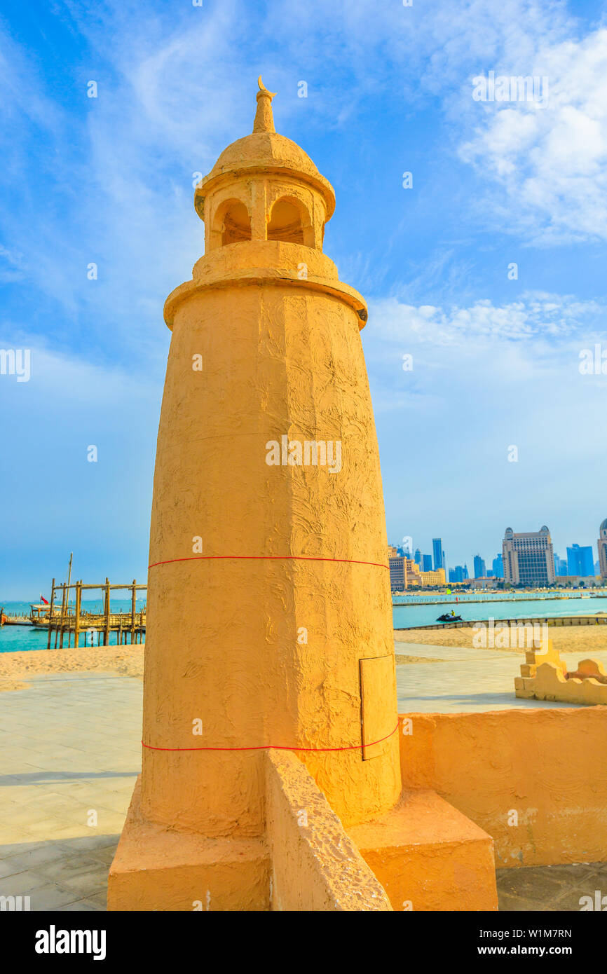 Katara Beach lighthouse with wooden boats and West Bay skyline on background in Doha Bay area