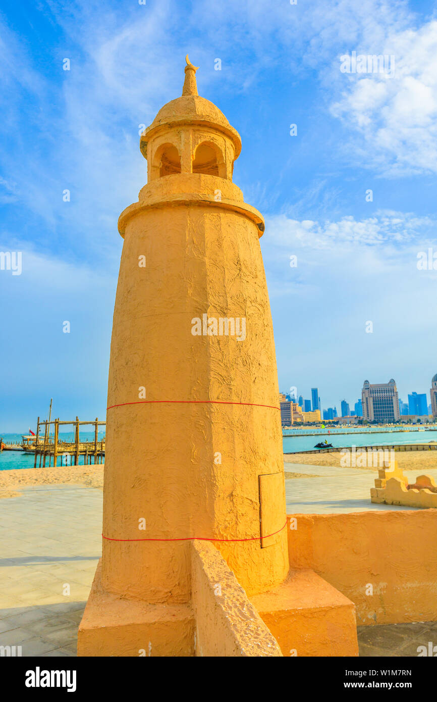 Katara Beach lighthouse with wooden boats and West Bay skyline on background in Doha Bay area near Katara cultural village. Qatar, Middle East Stock Photo
