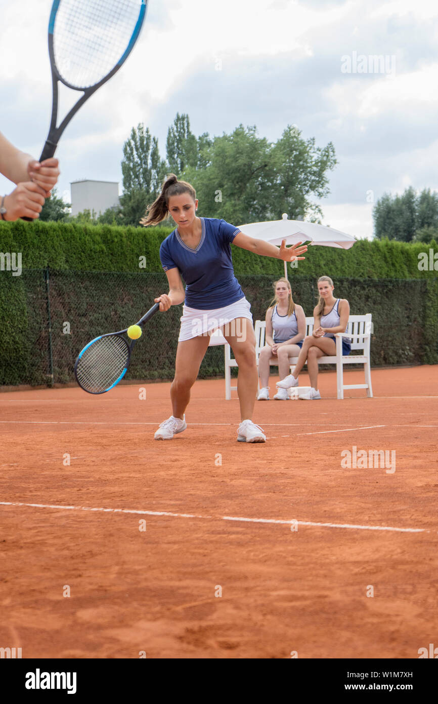 Women playing tennis on a sunny day, Bavaria, Germany Stock Photo