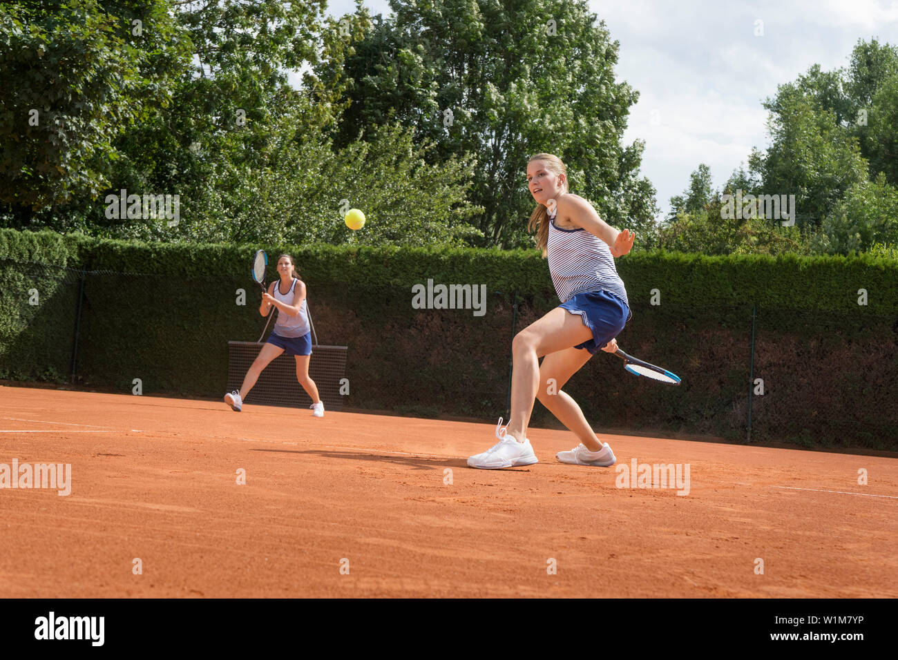Two women playing tennis on a sunny day, Bavaria, Germany Stock Photo