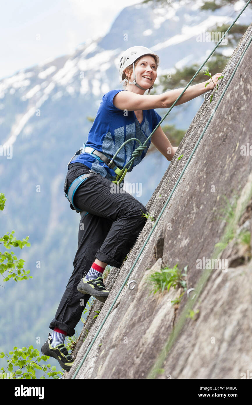 Female rock climber scaling a rock face at Oberried climbing garden, Otztal, Tyrol, Austria Stock Photo