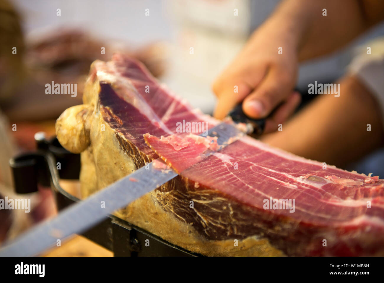 A vendor slices prosciutto at the weekly market in Sulmona Stock Photo