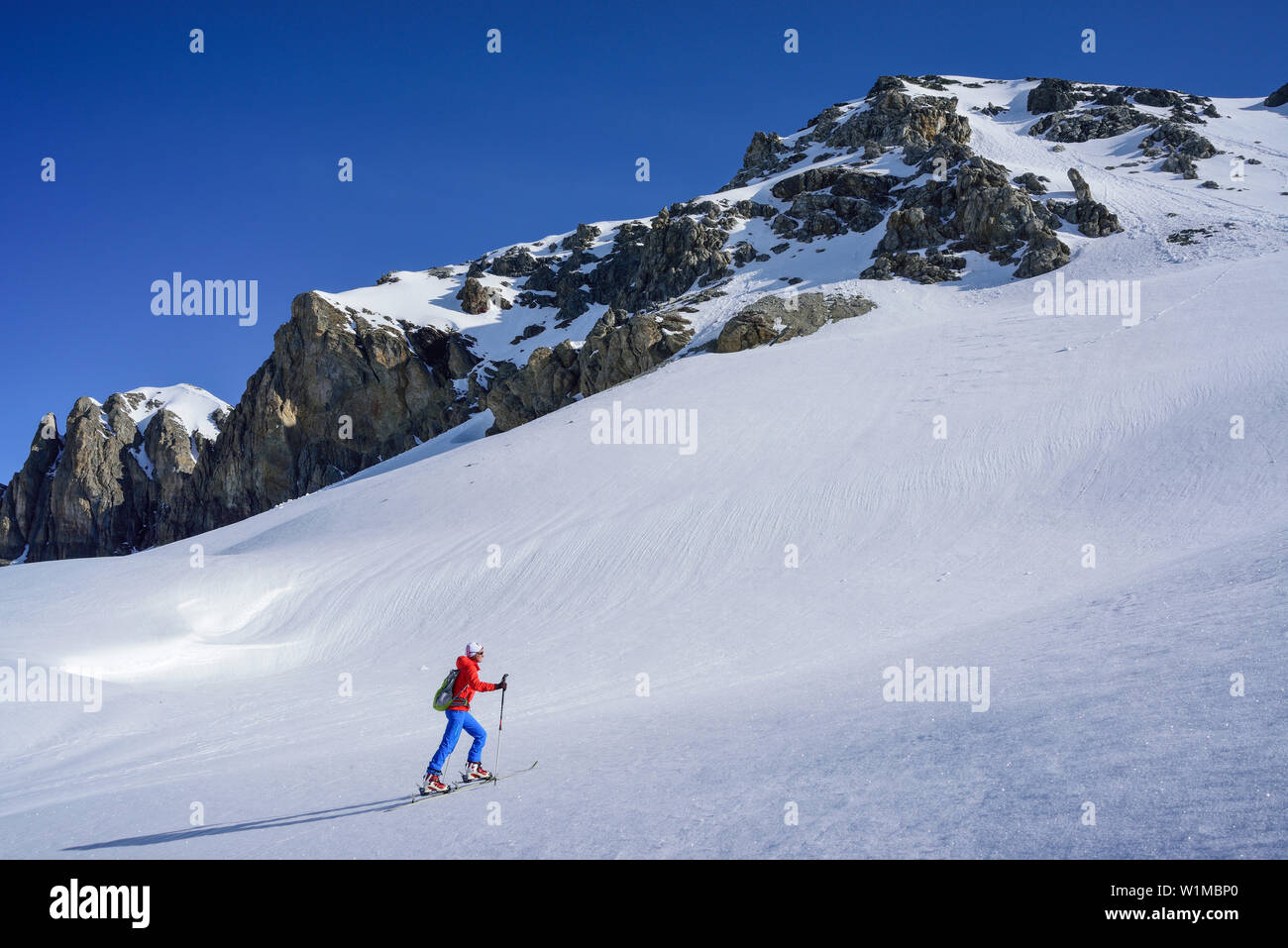 Woman back-country skiing ascending towards Piz Lischana, Piz Lischana, Sesvenna Alps, Engadin, Grisons, Switzerland Stock Photo