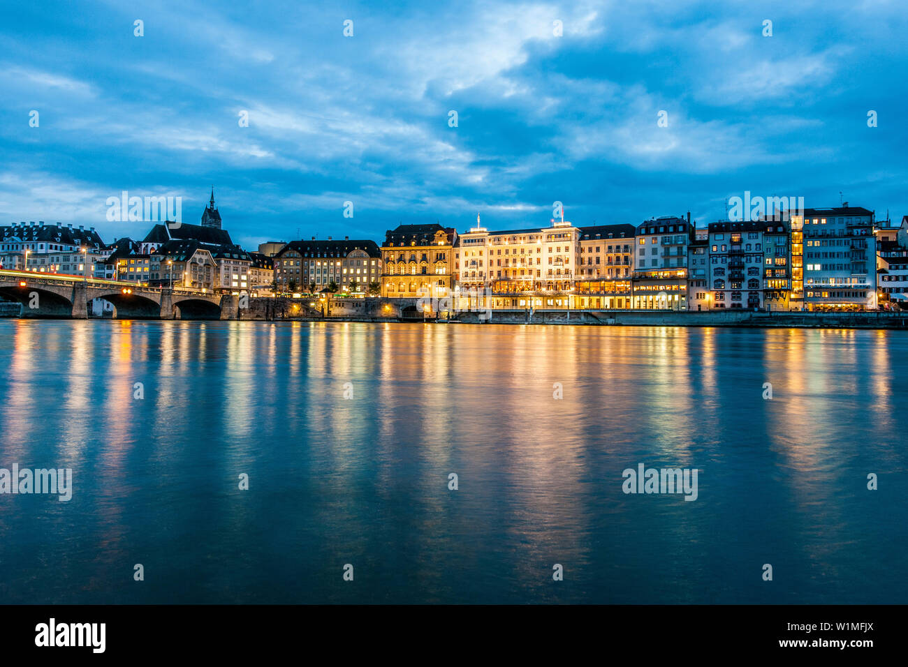 View over the river Rhine with Mittlere Bruecke (Middle Bridge) to a hotel in the evening, Basel, Canton of Basel-Stadt, Switzerland Stock Photo