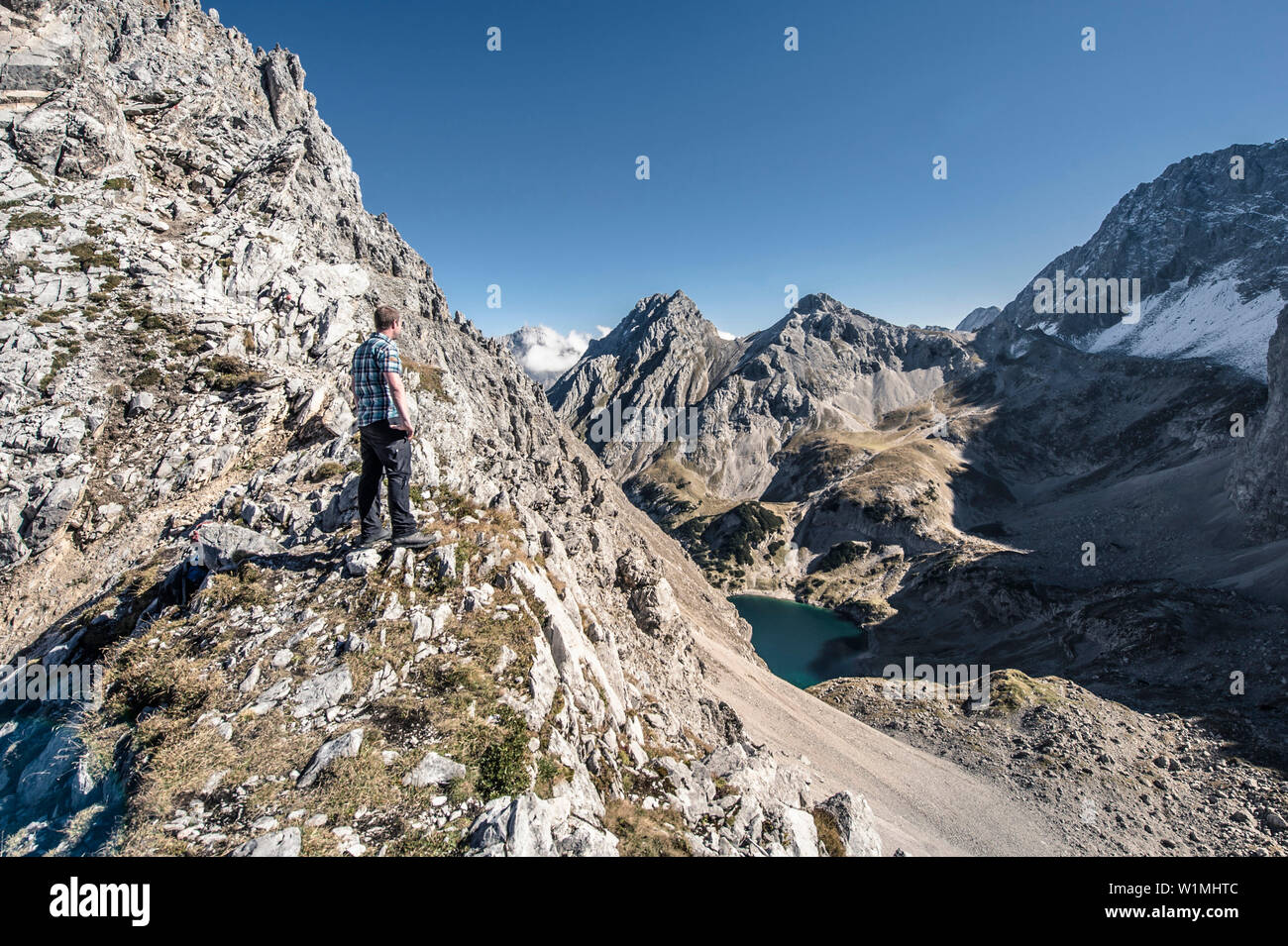 Wanderer looking towards lake Drachensee, Vorderer Drachenkopf Mountain ...