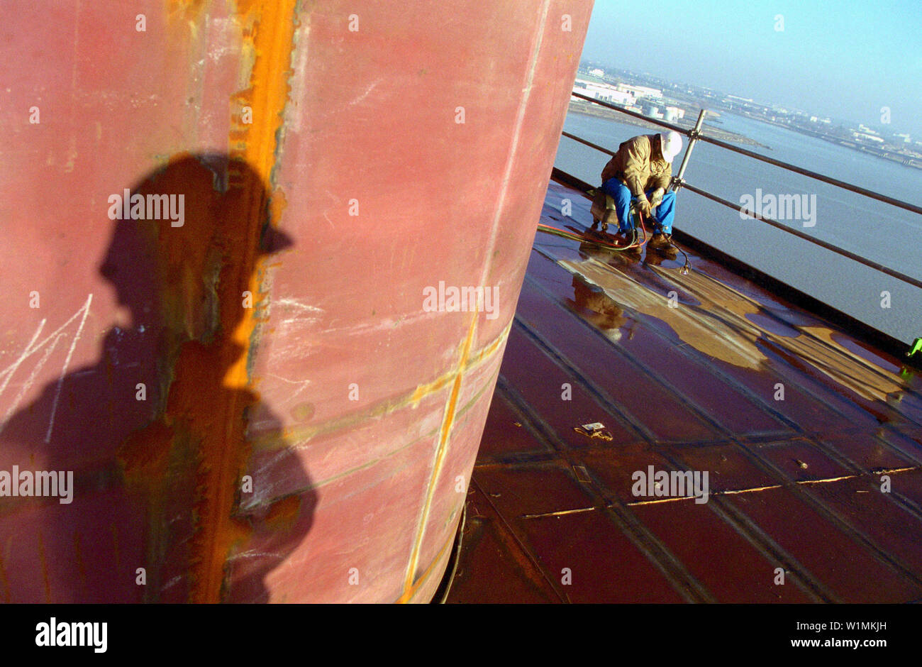 Worker and shadow, dry dock, Queen Mary 2, SaintNazaire, France Stock