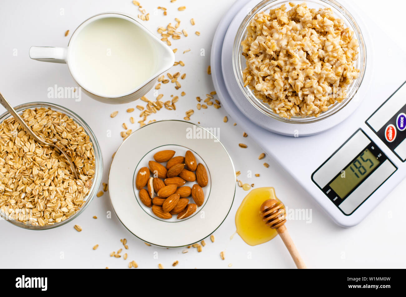 Balanced Diet Food And Slimming Concept Proper Nutrition Menu For Breakfast Oatmeal Porridge On Digital Kitchen Scales Almonds Milk And Honey Dipp Stock Photo Alamy