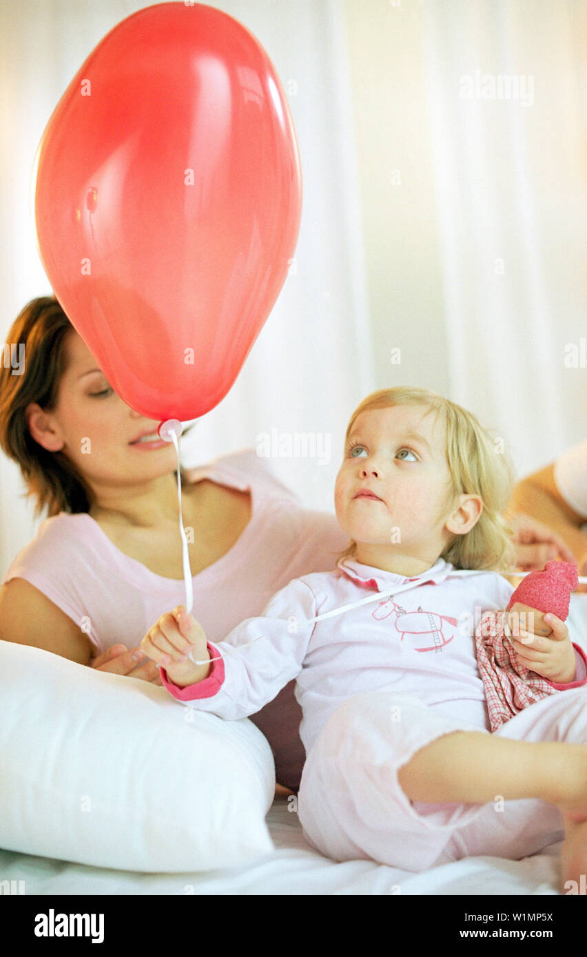 Toddler girl holding red balloon Stock Photo