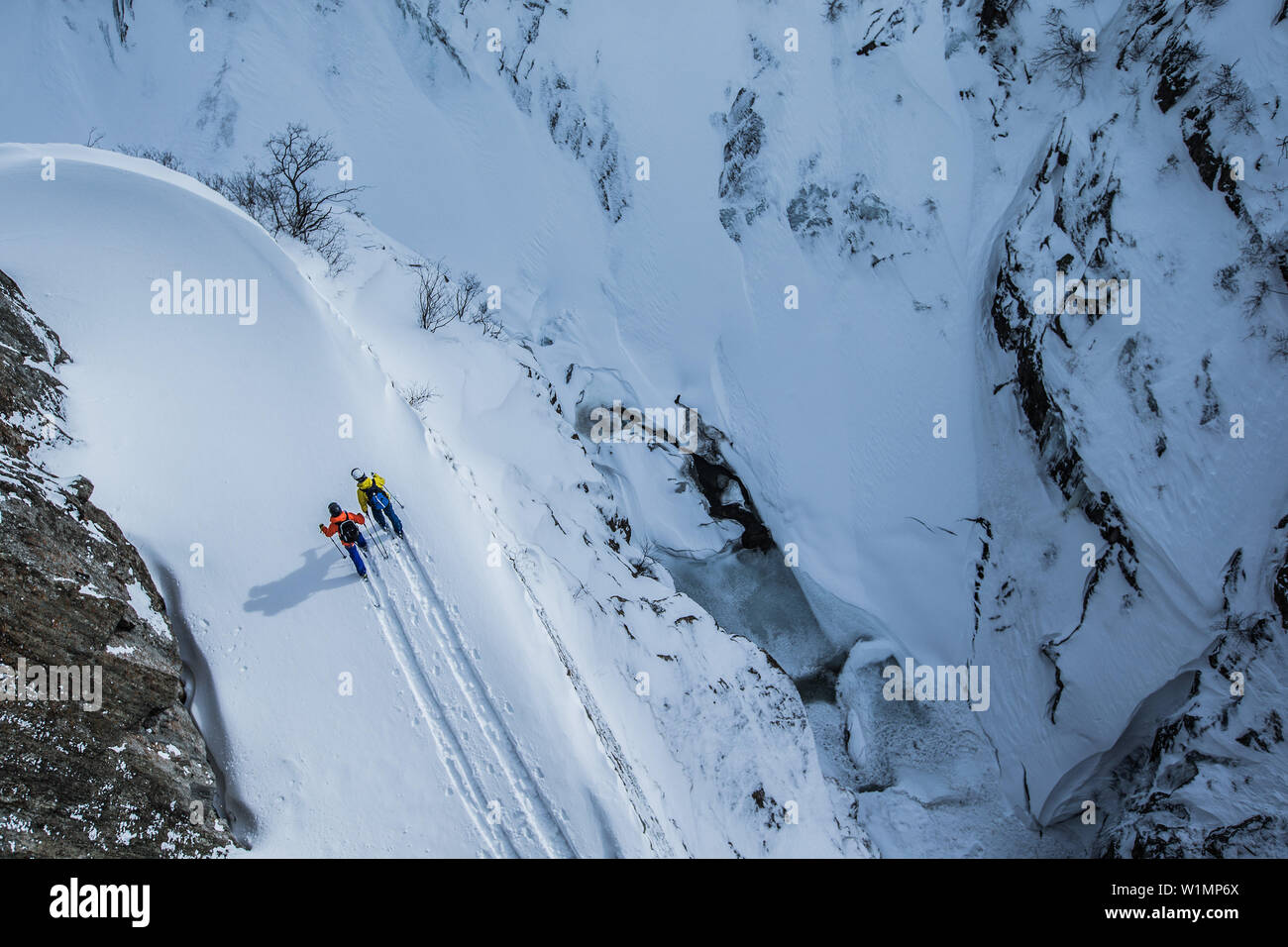 Two young freeskier hiking through the deep powder snow in the mountains, Andermatt, Uri, Switzerland Stock Photo