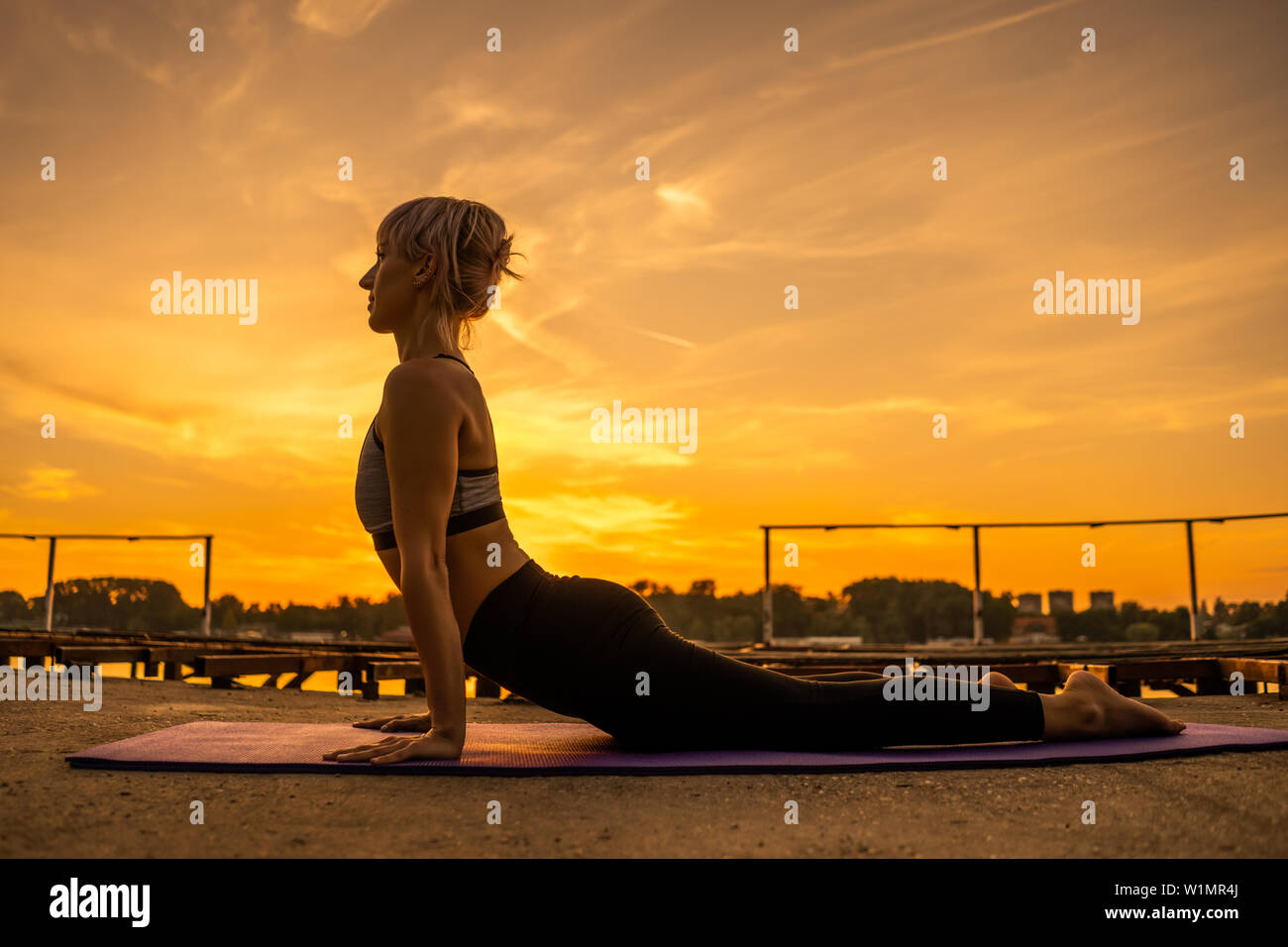 Woman practicing yoga in sunset. Bhujangasana/Cobra Pose Stock Photo ...