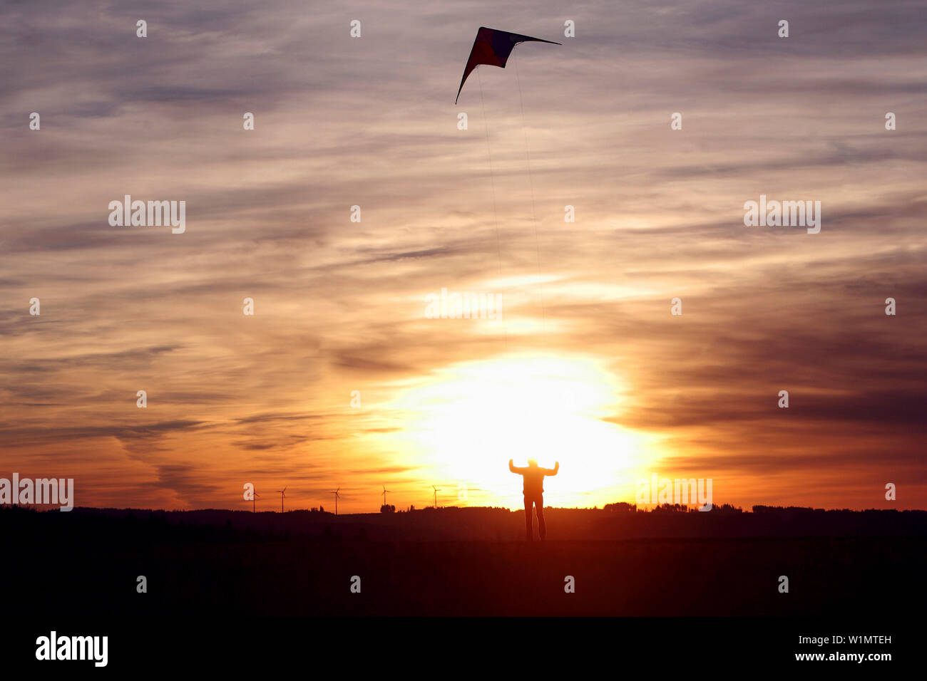 Young woman flying a kite, Kaufbeuren, Bavaria, Germany Stock Photo