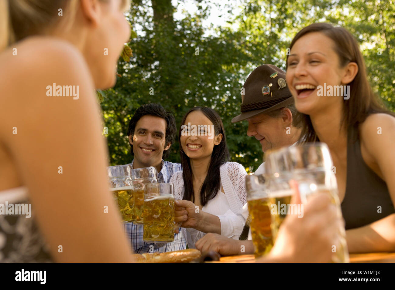 Friends in a beer garden, clinking glasses, Lake Starnberger, Bavaria, Germany Stock Photo
