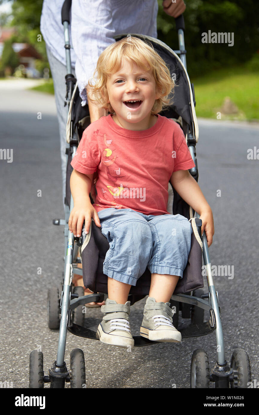 Boy sitting in a buggy Stock Photo Alamy
