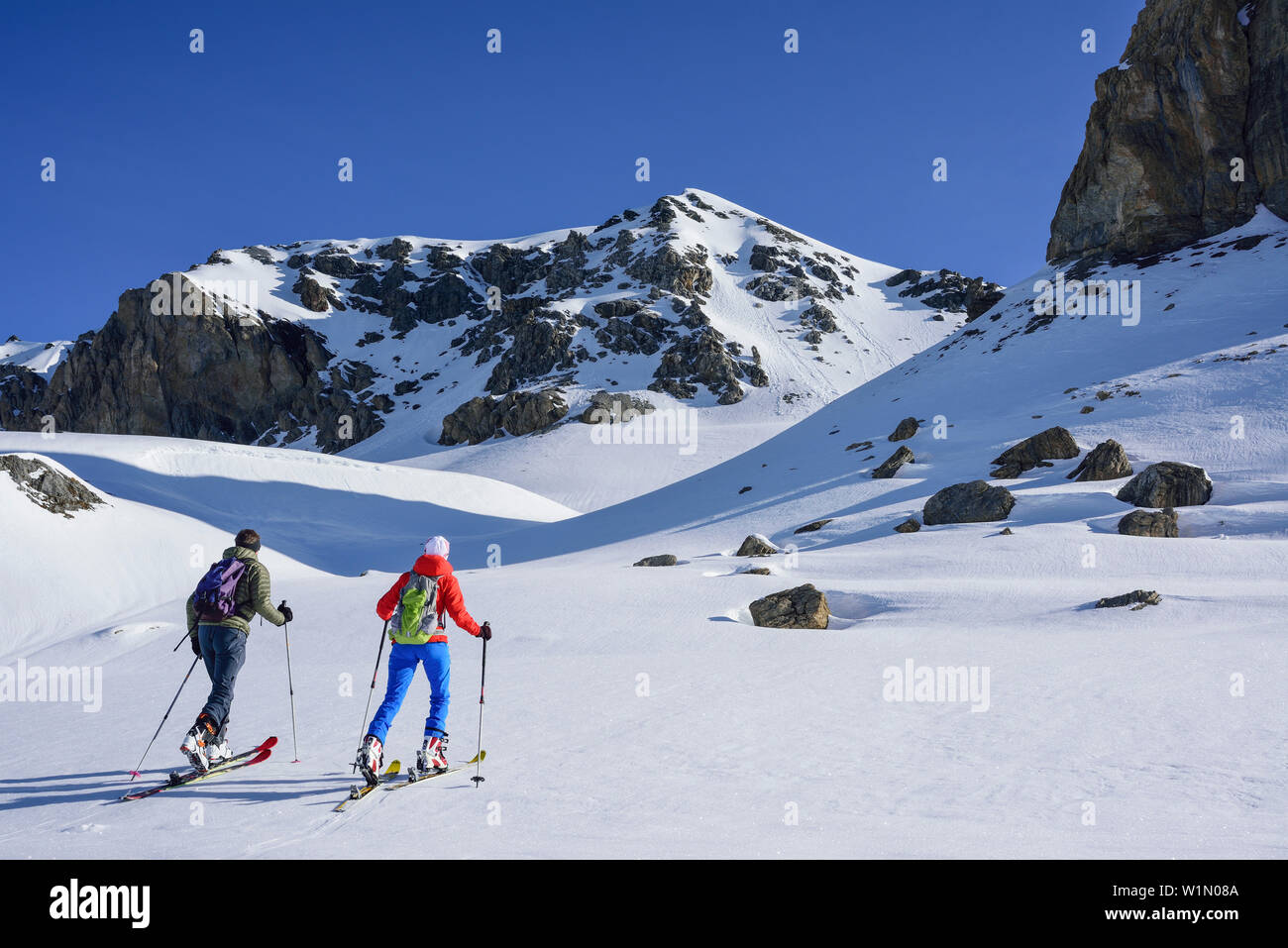 Two persons back-country skiing ascending towards Piz Lischana, Piz Lischana, Sesvenna Alps, Engadin, Grisons, Switzerland Stock Photo