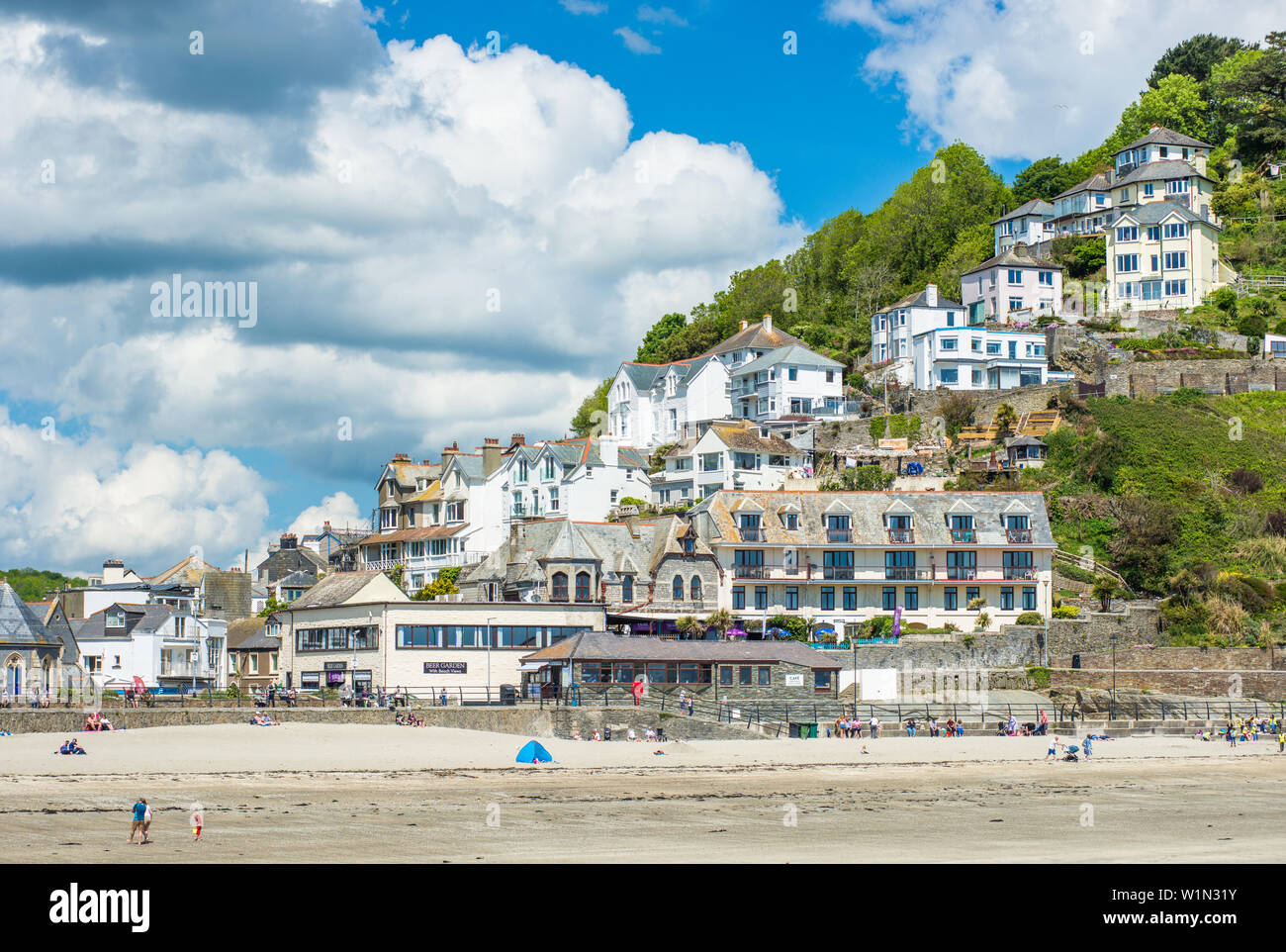 The small coastal town of Looe with hillside houses and a beach ...