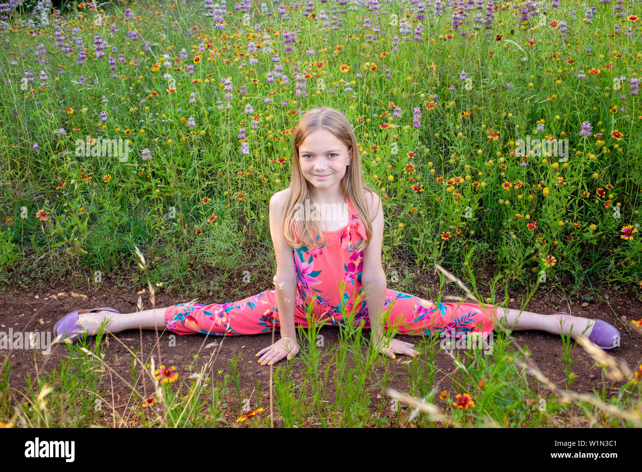 Girl doing a split in the wildflowers Stock Photo