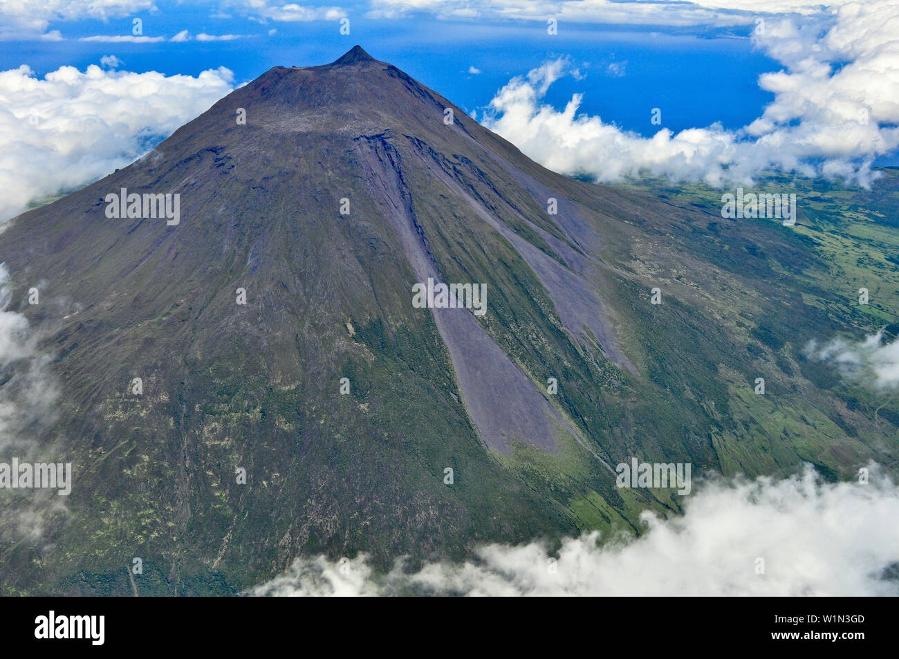 Aerial of volcano Montanha do Pico, Mount Pico with summit Pico Pequeno and crater above clouds, highest mountain of Portugal, stratovolcano, Island o Stock Photo