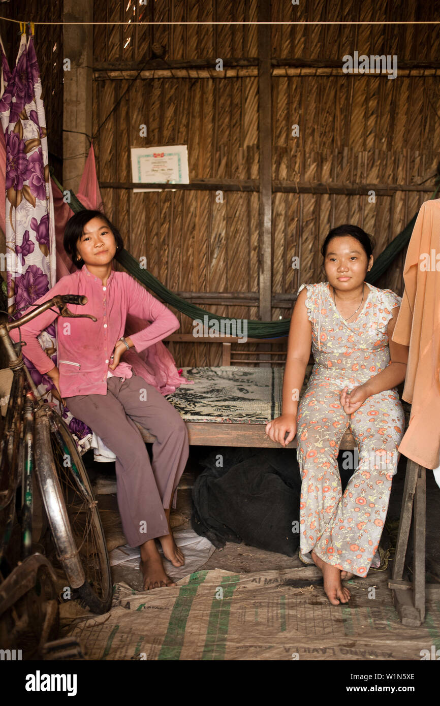 portrait of 2young Vietnamese girls sitting on their bed in their home in a village outside of Ho Chi Minh city Stock Photo