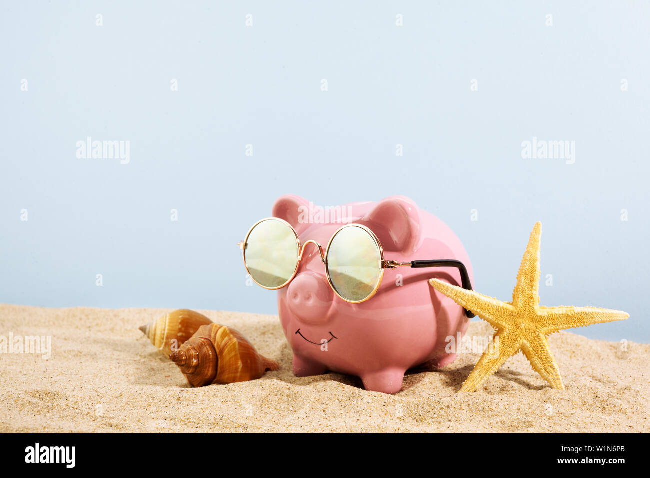 Piggy bank with sunglasses on the sand background Stock Photo - Alamy