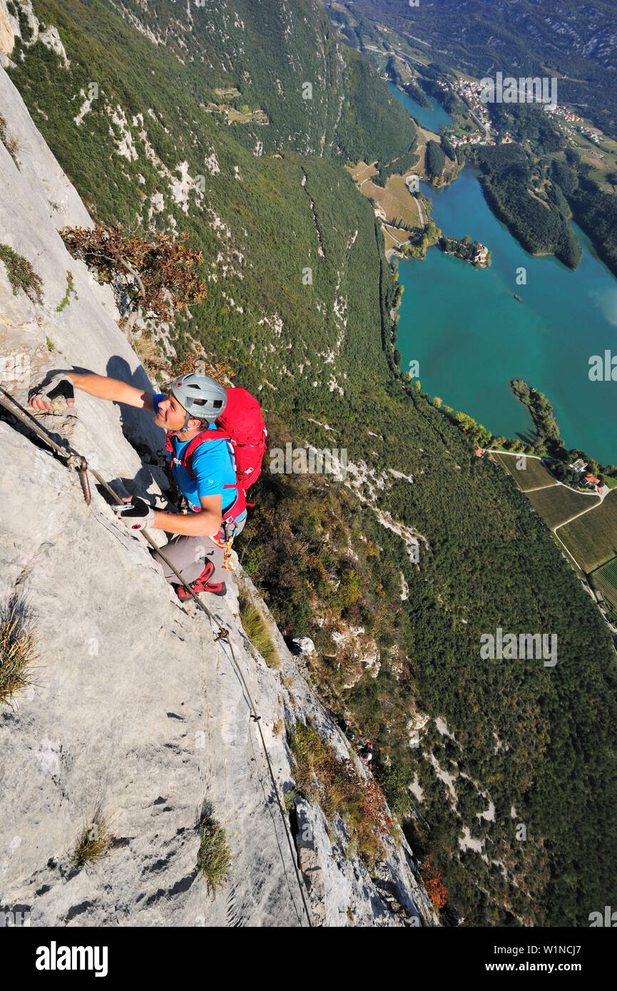 Young man climbing fixed rope route Rino Pisetta, Lago die Toblino, Sarche, Calavino, Trentino, Trentino-Alto Adige, Suedtirol, Italy Stock Photo