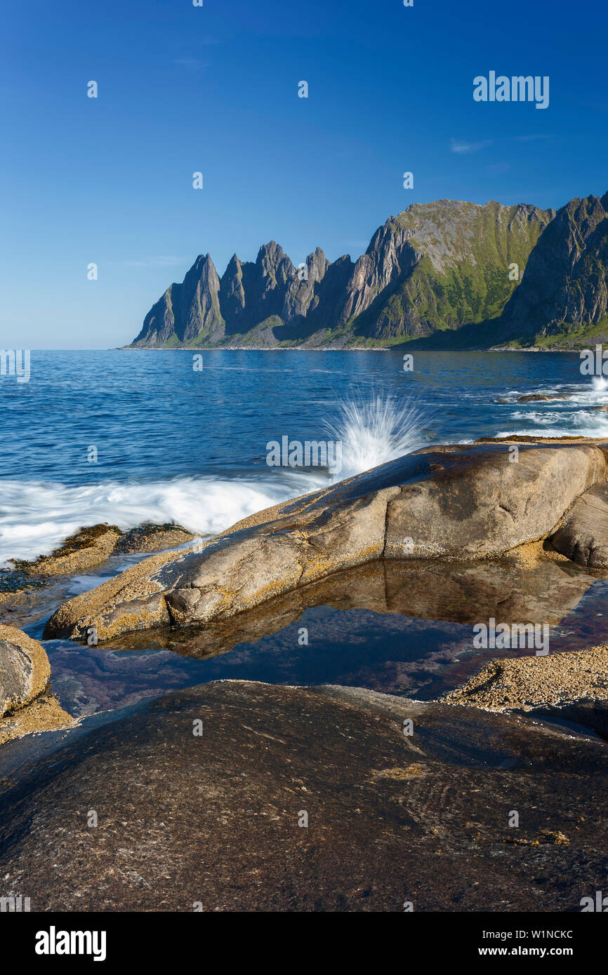 Okshornan rock peaks at Ersfjordr in northern Norway in summer with waves in the foreground, Senja, Troms Fylke, Norway, Scandinavia Stock Photo