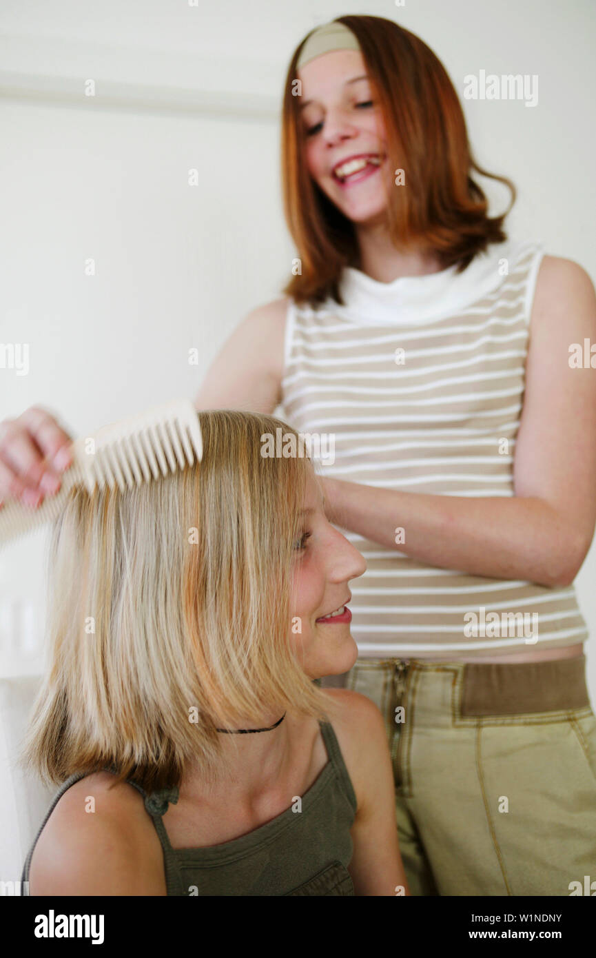 Teenager combing girl's hair Stock Photo