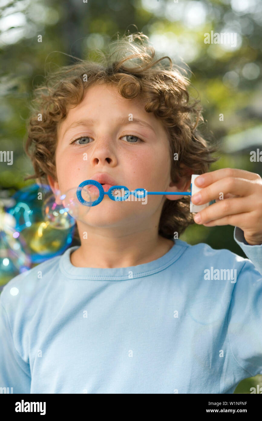 Boy blowing soap bubbles, children's birthday party Stock Photo Alamy